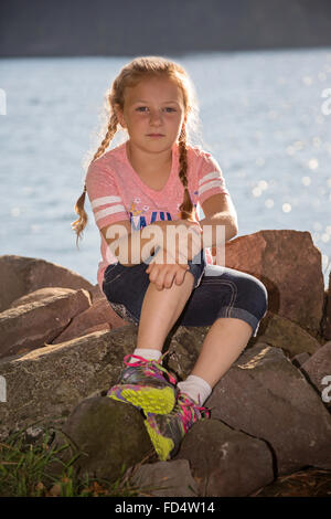 Felice giovane ragazza in posa all'aperto presso un parco vicino al fiume Foto Stock