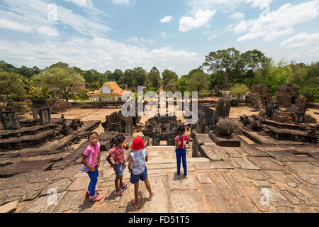I bambini sulla sommità del tempio Bakong, Gruppo Roluos, Angkor, Siem Reap, Cambogia Foto Stock
