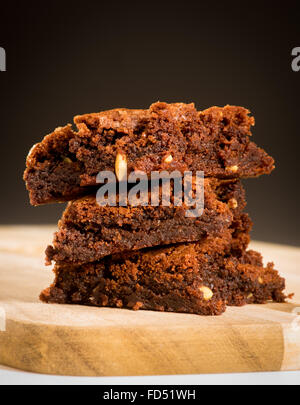 Tre Brownie al cioccolato impilati su una scheda con sfondo scuro Foto Stock