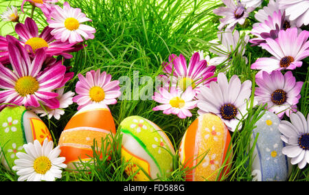 Fiori di Primavera e felice colorate le uova di Pasqua su erba fresca Foto Stock