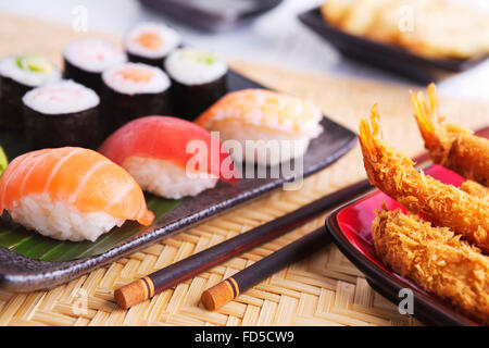 Tempura di gamberetti e vari sushi giapponese su una piastra. Foto Stock