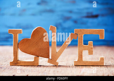 Alcune lettere di legno costituente la parola amore, con un cuore di legno  al posto della lettera o contro un rustico blu sullo sfondo di legno Foto  stock - Alamy