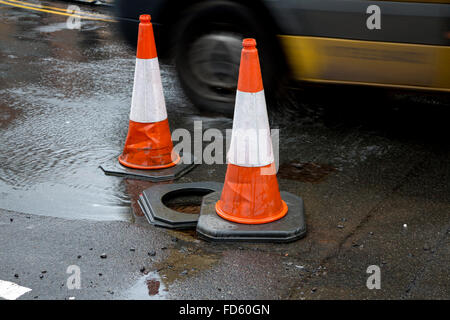 Traffico coni in acqua a una perdita principale in un road, REGNO UNITO Foto Stock