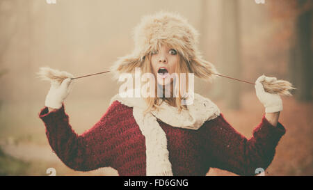 Ritratto di surprsied stupito molto di moda donna in caduta Forest park. Splendida fanciulla in pelliccia Cappello invernale e un maglione. Foto Stock