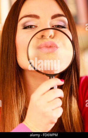 Esplorazione di indagine il concetto di istruzione. Closeup donna divertente faccia, ragazza tenendo sulle labbra lente di ingrandimento Loupe Foto Stock