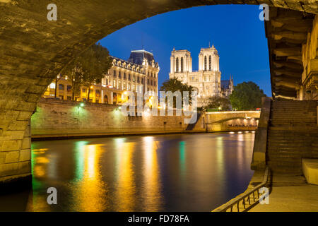 Twilight sotto Pont Saint Michel con la cattedrale di Notre Dame e il Fiume Senna e PREFECTURE DE POLICE DI PARIGI, FRANCIA Foto Stock