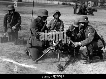 Soldati con maschere antigas durante un tiro al bersaglio a una mitragliatrice, 1932 Foto Stock