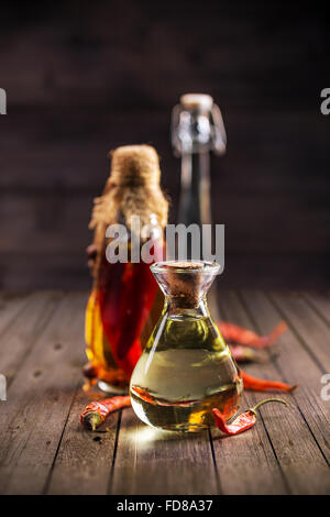 Assortimento di oli piccante con erbe e spezie in diverse bottiglie Foto Stock