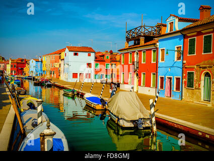 Case colorate e barche lungo un canale nell'isola di Burano nella Laguna veneziana, Venezia Italia Foto Stock