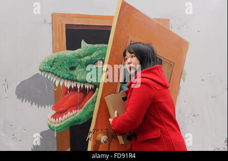 Chongqing Cina. 29 gen, 2016. Una donna pone con la tecnica del trompe-l'oeil a Sanxia piazza di Chongqing, a sud-ovest della Cina, 29 gennaio, 2016. Trompe-l'oeil è una tecnica che utilizza immagini realistiche per creare l'illusione ottica che oggetti rappresentati esistono in tre dimensioni. © Tang Yi/Xinhua/Alamy Live News Foto Stock