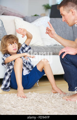 Padre e figlio discutere in casa e compiendo gesti Foto Stock