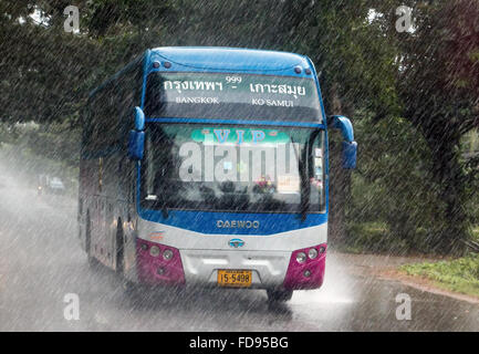 Bus va giù per la strada sotto la pioggia Foto Stock