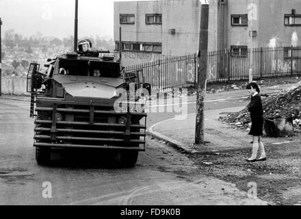 Un veicolo blindato noto come un "suino" dal Queens reggimento di pattuglia passa una scolaretta in uniforme a Belfast , Irlanda del Nord in aprile 1984 . Quasi duemila soldati del reggimento con oltre 200 dal Sussex erano stazionati in Irlanda al momento Foto Stock