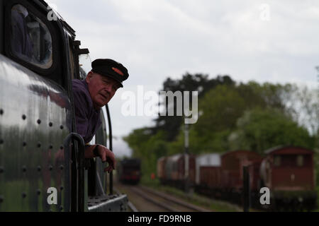 Treno a vapore driver attende la bandiera verde segnale sul grande stazione ferroviaria centrale Foto Stock