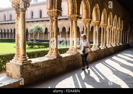 Donna che cammina nel chiostro della Cattedrale di Monreale in provincia di Palermo, Sicilia Foto Stock