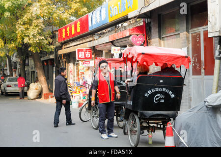 Il cinese rickshaw driver a fare la spesa per produrre in un mercato all'aperto nel centro di Pechino, Cina. Foto Stock