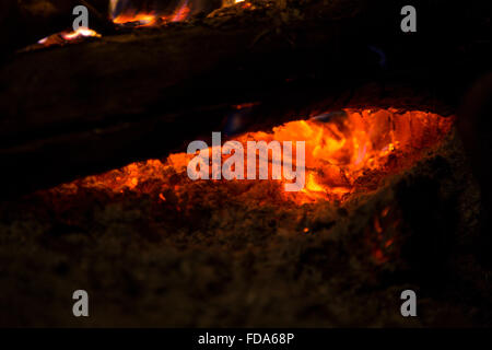 Vista ingrandita di tizzi caldi e ceneri a sinistra da un fuoco di legno Foto Stock