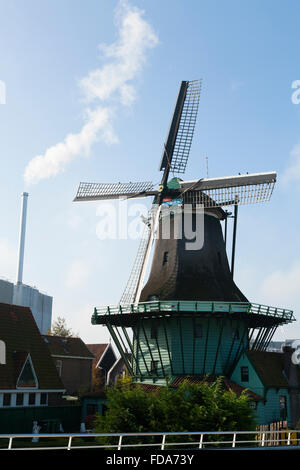 De Bleeke Dood. Il mulino a vento di Smok; mulino di farina Zaanse Schans, Holland Olanda. Sun blue sky e vapore dalla moderna industria dietro Foto Stock