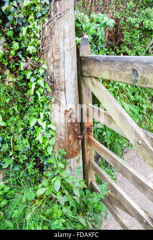 Un vecchio arrugginito catena su un cancello in legno e gatepost Foto Stock