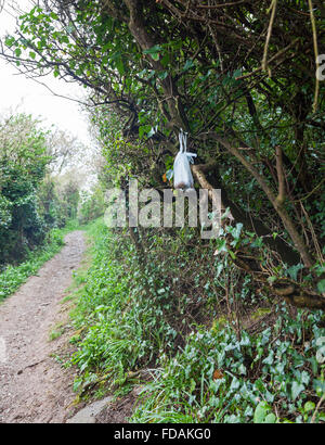 Un poo sacchetto appeso su una boccola a sinistra da un dog walker Foto Stock