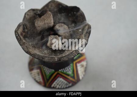 Bruciatore di incenso con bruciando incenso fornito con caffè in Etiopia rurale. Foto Stock