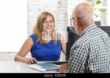 Una donna di affari con computer portatile e dare consigli per il suo cliente. Foto Stock