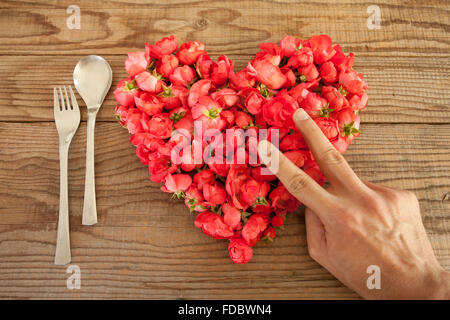 Cuore di rose rosse in background in legno, ricoperto da un lato di rappresentare sentimenti personali Foto Stock