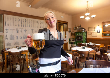 La cameriera che serve birra birra ceca vetro della Pilsner Urquell presso il ristorante di Praga "U Pinkasu', Repubblica Ceca Foto Stock