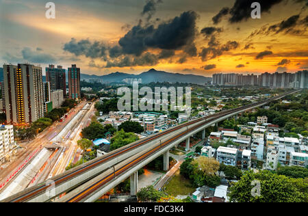 Hong kong cityspace e treno veloce al tramonto Foto Stock