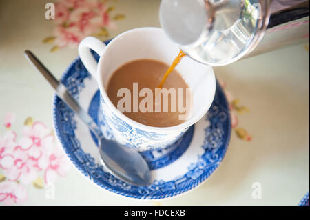 Versando il tè in bone china tazza da caffè con piattino al castello di tamburo in Aberdeenshire, Scozia. Foto Stock