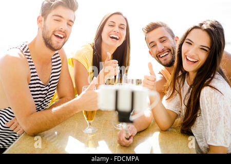 Gruppo di amici al bar sulla spiaggia e facendo un selfie Foto Stock