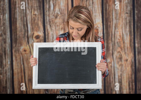 La donna mantiene un vuoto segno della lavagna Foto Stock