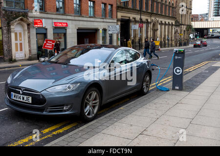 Auto elettrica punto di carica con una macchina e un modello di Tesla S, collegati, Blackfriars Street, Manchester, Regno Unito Foto Stock