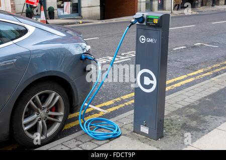 Auto elettrica punto di carica con una macchina e un modello di Tesla S, collegati, Blackfriars Street, Manchester, Regno Unito Foto Stock