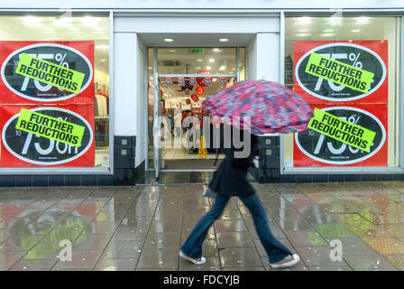 Gli amanti dello shopping a piedi passato segni di vendita nelle vetrine di negozi nel centro città di Brighton. Foto Stock