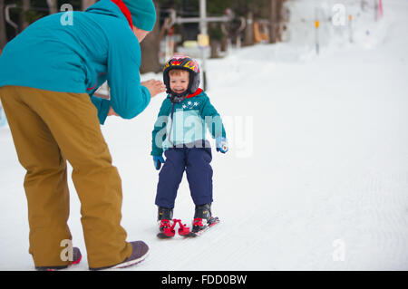 Bella giovane papà e il suo bambino boy, sci in montagna Foto Stock