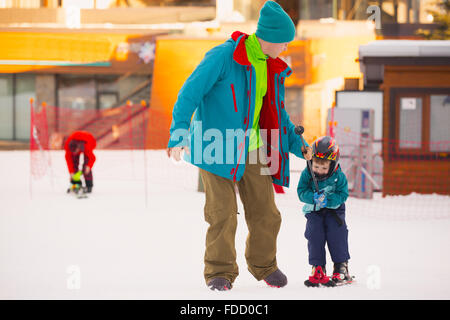 Bella giovane papà e il suo bambino boy, sci in montagna Foto Stock