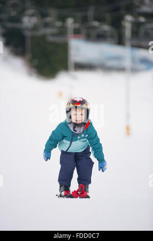Il toddler boy Sciare in montagna invernale Foto Stock