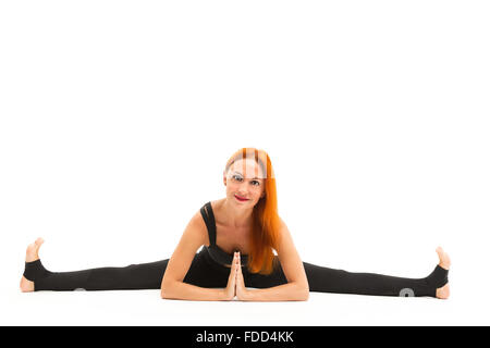 Sporty giovane e bella donna che indossa abbigliamento sportivo facendo suddivide lo Yoga asana, studio a lunghezza piena vista, isolato Foto Stock
