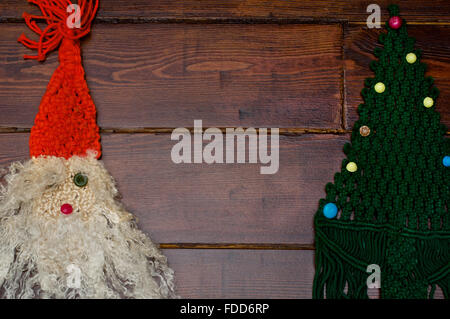 Tessuto di Babbo Natale e albero di Natale sullo sfondo di legno Foto Stock