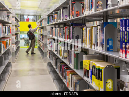 Uomo che guarda i libri in pile del moderno Seattle Central Library, design da architetti Rem Koolhaas e Joshua Prince-Ramus Foto Stock