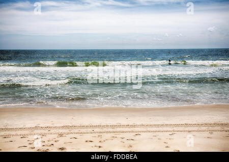 Un surfista scorre in un'onda a Kure Beach, Carolina del Nord. Foto Stock