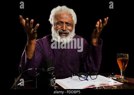 1 Senior indiano Adulto Uomo giornalista prenotare scrivendo a piangere pregiudizio faccia abuso di droga dipendenza Foto Stock