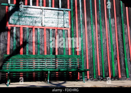 Banco di verde nella parte anteriore di un piccolo capanno Foto Stock