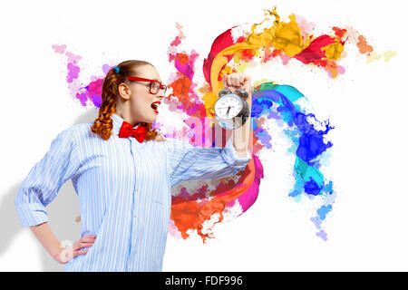 Giovane donna con un vecchio orologio sveglia Foto Stock