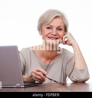 Vecchia donna senior di navigare in internet utilizzando il computer portatile Foto Stock