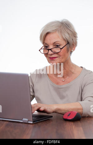 Vecchia donna senior di navigare in internet utilizzando il computer portatile Foto Stock