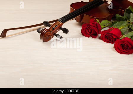 Rose rosse e un violino sul tavolo Foto Stock