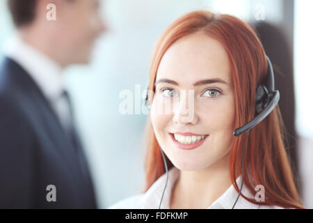 Ritratto di un sorridente imprenditrice creativa con auricolare in carica Foto Stock