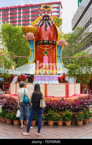 La gente che legge le previsioni su un cinese Zodiaco decorazione a Waterloo St per celebrare il capodanno cinese della scimmia, Singapore Foto Stock